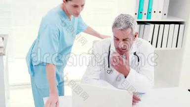 专心的医生看着笔记本电脑